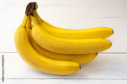Ripe yellow bananas on white wooden table. Delicious nutritious fruit for snack.