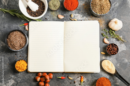 Fototapeta Naklejka Na Ścianę i Meble -  Notebook for recipes and spices on grey table