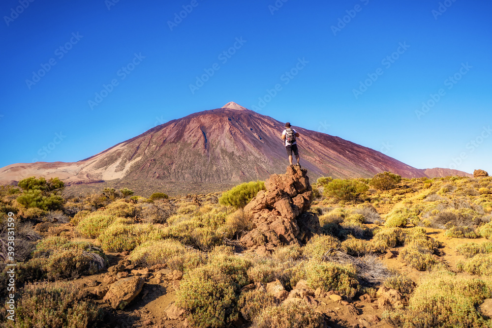 a man with his back on a rock looking at a mountain a man with his back on a rock looking at a mountain