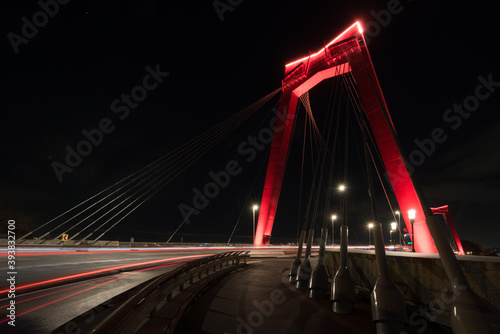 Fototapeta Naklejka Na Ścianę i Meble -  willembrug rotterdam is lit at night, with the red color contrasting nicely with the night