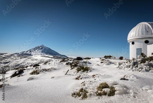 Bild auf Leinwand snowy landscape where you see a house and a mountain and a blue sky