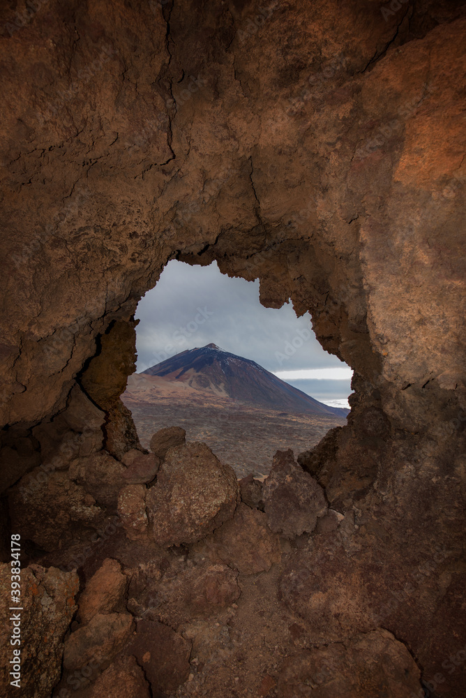 a mountain is seen through a rock window warm and soft tones