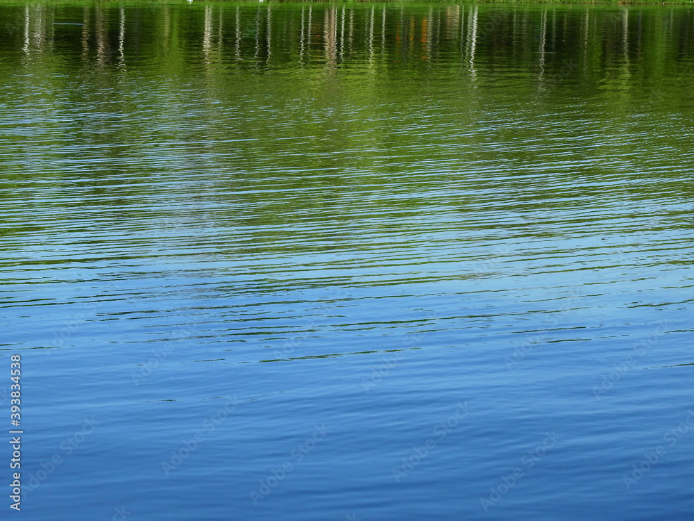 abstract water wave with reflection of tree and blue sky background abstract water wave with reflection of tree and blue sky background