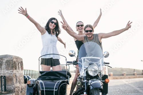 Happy friends posing on sidecar. Funny summer moments in Jaen, Spain.