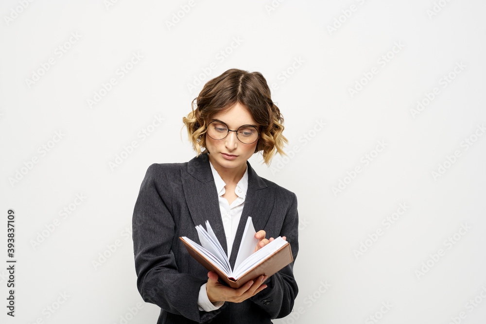Woman at work with book in hand light background classic suit glasses head Woman at work with book in hand light background classic suit glasses head