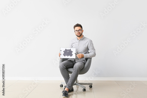 Male psychologist sitting i...