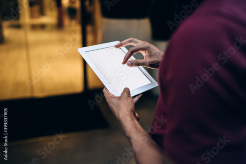 Crop man browsing tablet with finger
