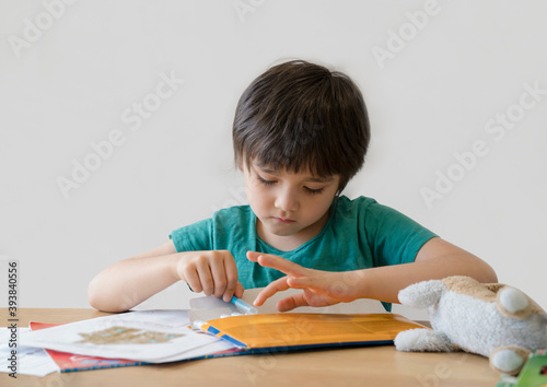 Active boy selecting his favorite colour pen for painting,School kid using a pen drawing on white paper, child relaxing at home,Home schooling, Distance education,E-learning concept