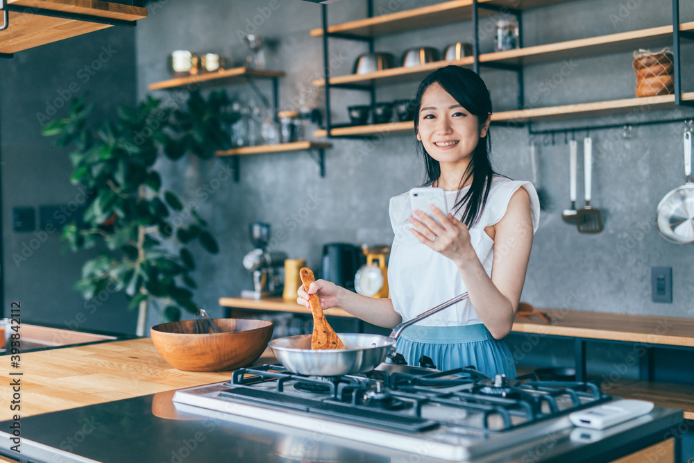 スマホで料理する女性
スマホで料理する女性