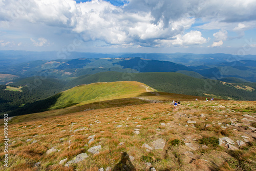 White clouds on a Blue sky over a large green meadow. High green mountain photo