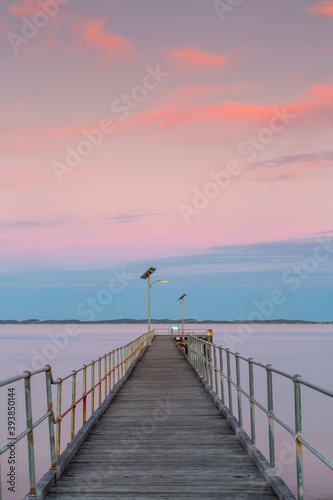 Fototapeta Naklejka Na Ścianę i Meble -  A long exposure pastel sunset over the Robe wooden jetty lcoated in Robe South Australia on November 9th 2020
