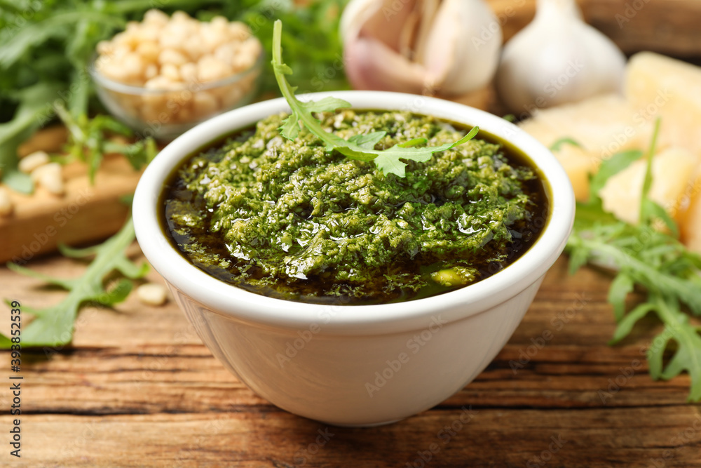 Bowl of tasty arugula pesto on wooden table, closeup Bowl of tasty arugula pesto on wooden table, closeup