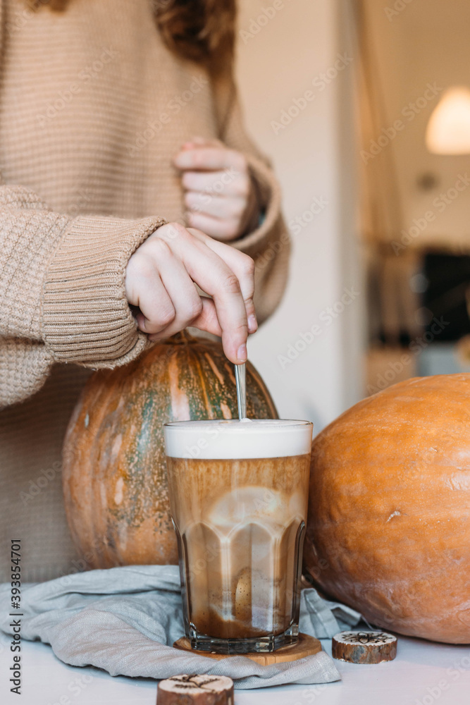 Girl stirring pumpkin latte. Hot autumn drink. High quality photo Girl stirring pumpkin latte. Hot autumn drink. High quality photo
