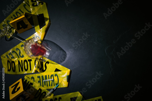 Obraz na plátne Flat lay composition with evidences and crime scene tape on black slate backgrou