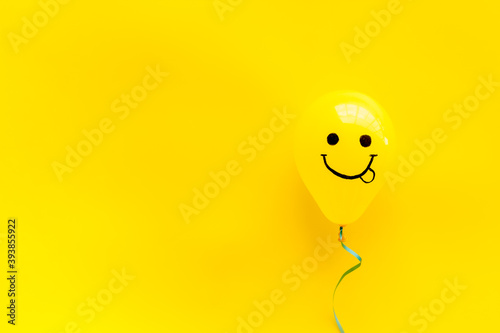 Happiness emotion face on balloon - joy mood background. Top view, copy space