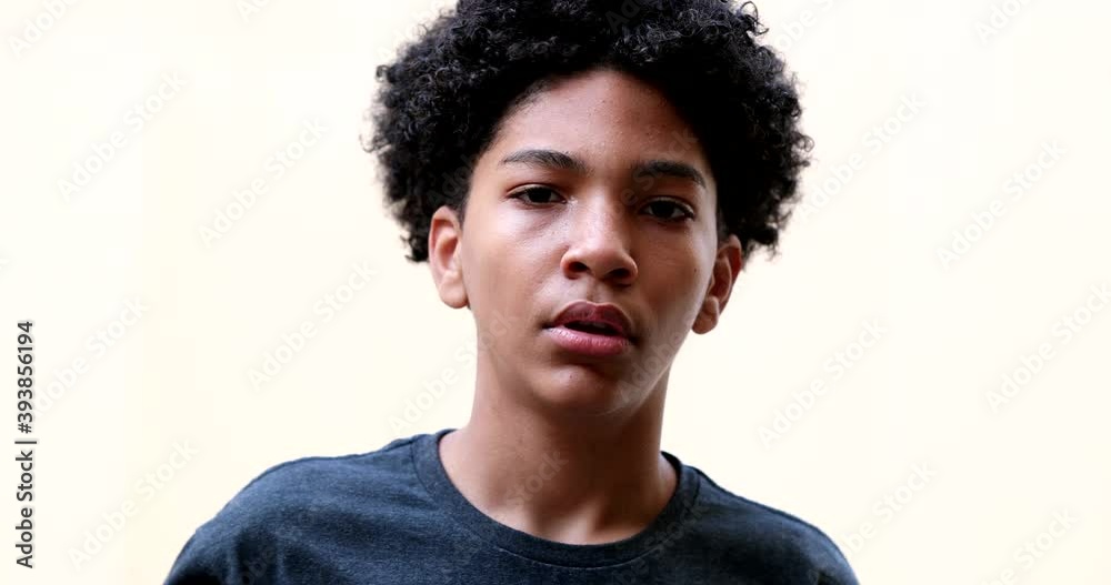 Serious Hispanic young boy portrait face staring at camera