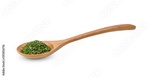 Dried parsley in wood spoon on a white background