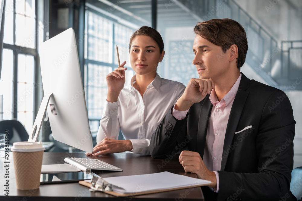 Male and female office managers discussing work, man in black suit and ...