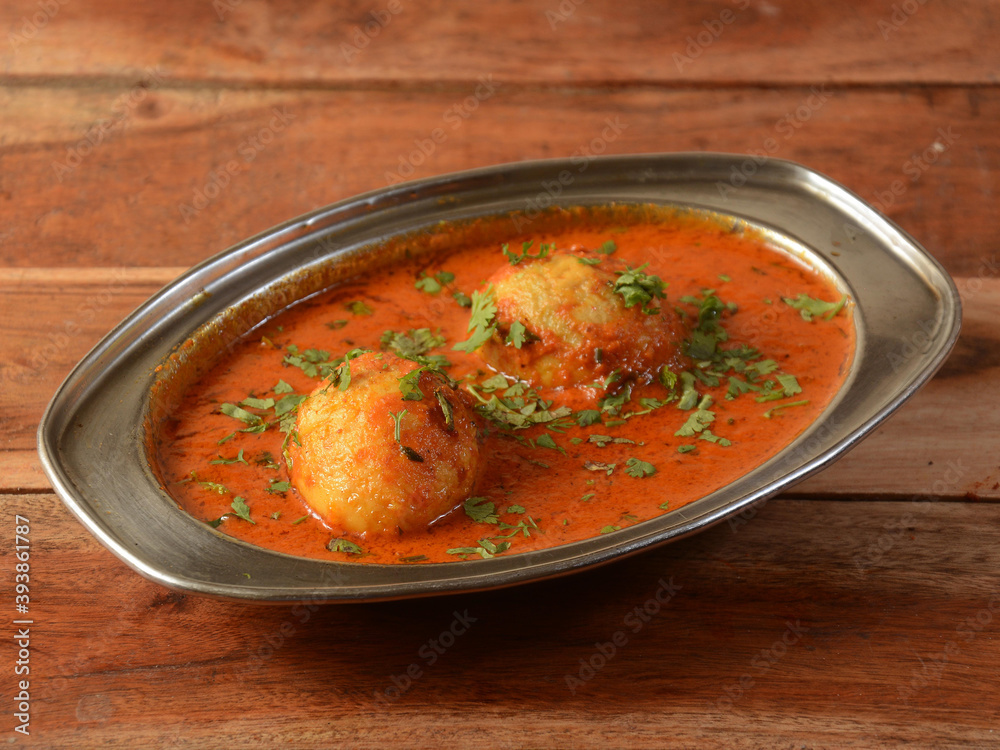 Anda Masala or Egg Curry is popular indian spicy food, served in a ceramic bowl over rustic wooden background. Selective focus Anda Masala or Egg Curry is popular indian spicy food, served in a ceramic bowl over rustic wooden background. Selective focus