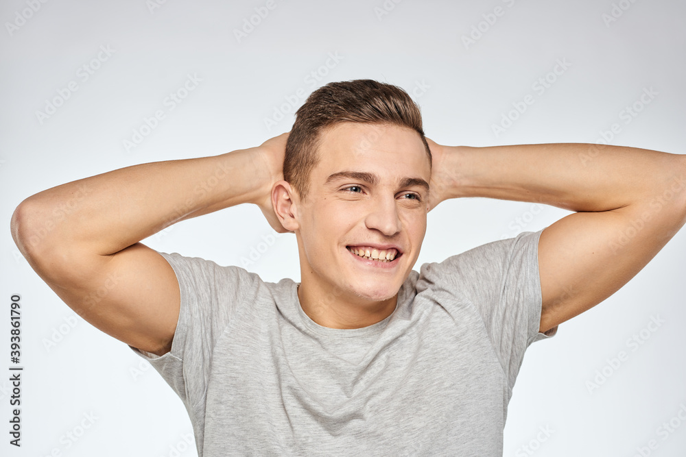 Cheerful emotional man gray t-shirt gesturing with hands studio lifestyle Cheerful emotional man gray t-shirt gesturing with hands studio lifestyle