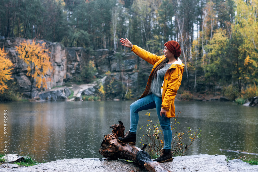 Girl in a yellow jacket and brown hat shows his hands in the distance ...