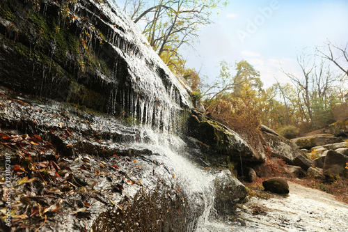 Picturesque view of beautiful waterfall in forest on autumn day