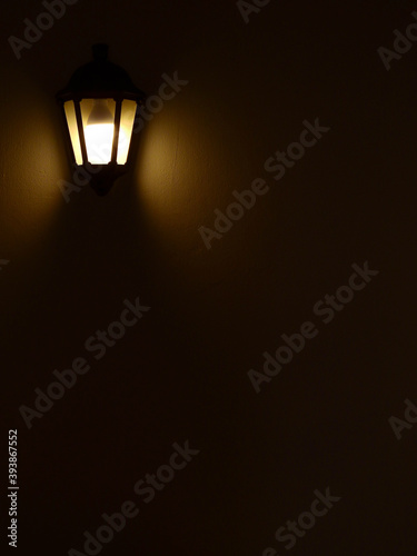 classic lamp with light on the wall in the dark room
