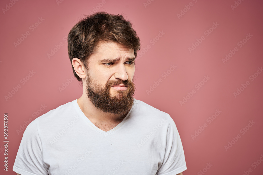 Fototapeta premium emotional man white t shirt sad facial expression pink background
