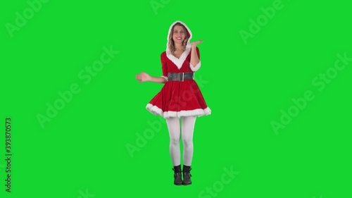 Attractive Santa Claus woman in red costume posing and modelling at camera. Full body length on green screen. 