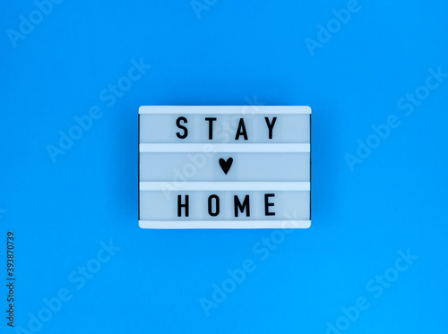 Light box with Stay home quote on a blue background.