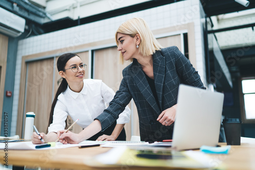 Businesswoman looking at coworker standing in office room