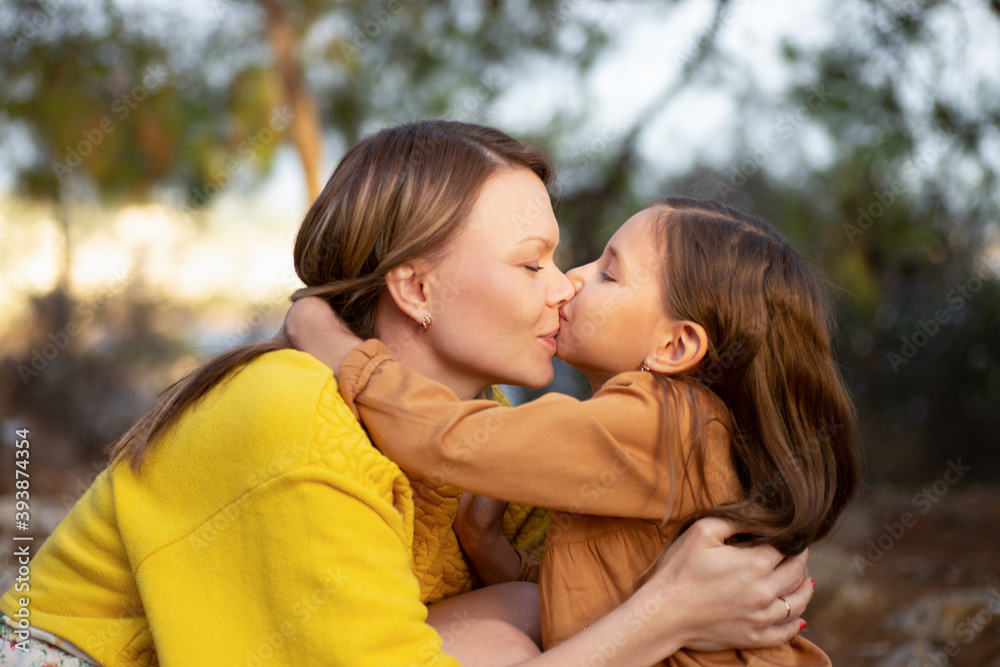 Mother and child walking and kissing in autumn park. Mother and child walking and kissing in autumn park.