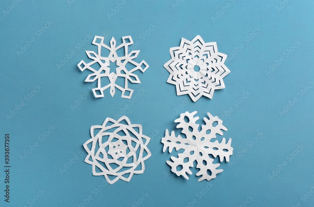 Many paper snowflakes on turquoise background, flat lay Many paper snowflakes on turquoise background, flat lay