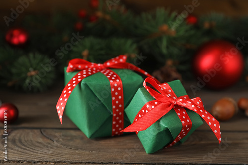 Green Christmas gift boxes with red bows on wooden table
