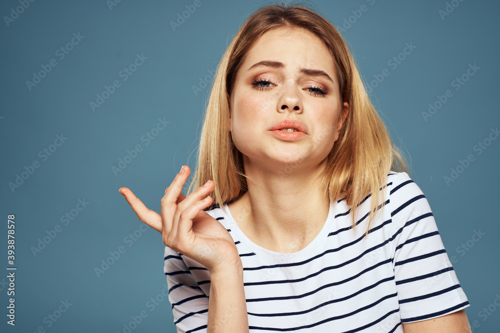 woman wearing striped t-shirt cropped view blue isolated background displeased facial expression woman wearing striped t-shirt cropped view blue isolated background displeased facial expression
