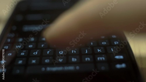 a woman types a text message on her smartphone, taking a macro shot of the smartphone screen