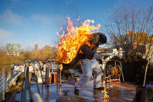 Burning stuntman danger job with fire. Dangerous work of a rescuer, firefighter. Fire on the ship.