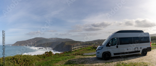 camper van parked high up on cliffs of a wild and rugged coastline photo