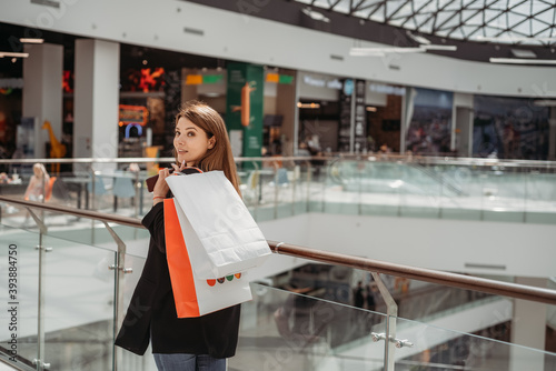 Beatiful dark-haired girl with a shopping bag at the mall
