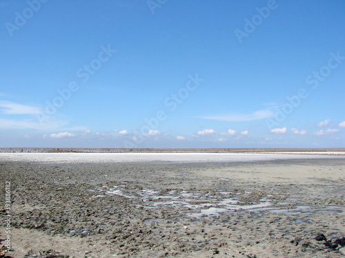 Landscape of blue barely cloudy sky reflected on the water surface of a semi-dried salt lake.