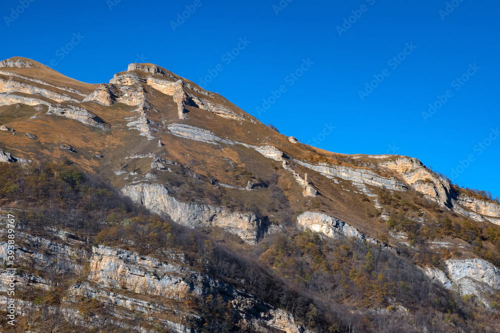 Rocks and dry grass in North Caucasus mountains in autumn on sunny day Rocks and dry grass in North Caucasus mountains in autumn on sunny day