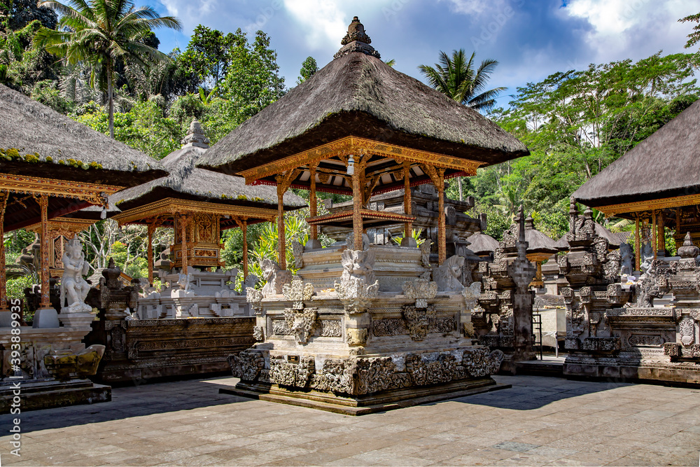 Bali temple entrance with many old statues various local deities in a beautiful garden on Bali, Indonesia.
