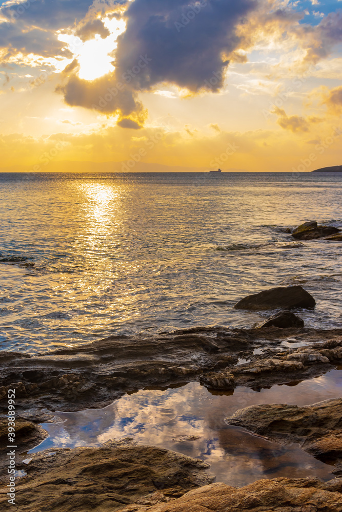 Spiegelung der Wolken bei Sonnenuntergang an der felsigen Küste auf der griechischen Kykladeninsel Tinos Spiegelung der Wolken bei Sonnenuntergang an der felsigen Küste auf der griechischen Kykladeninsel Tinos