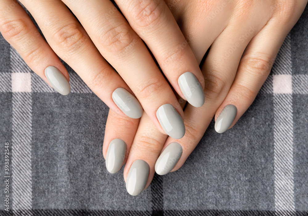 Beautiful womans hands with manicure close up on gray background. Beautiful womans hands with manicure close up on gray background.