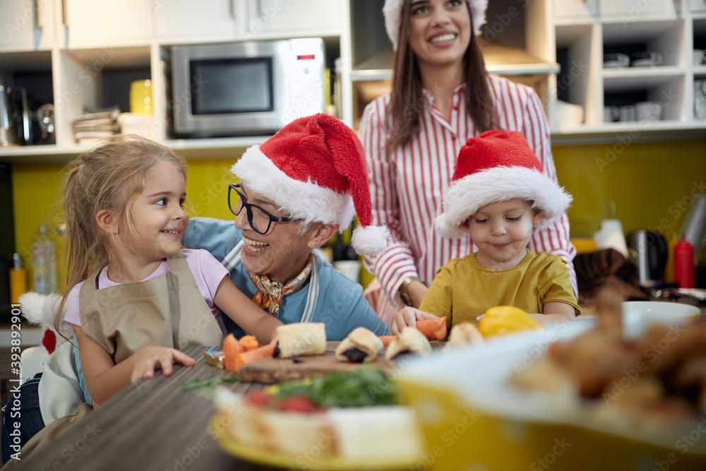 Grandmother and mother enjoying with children in the kitchen for a Xmas. Christmas, family, together