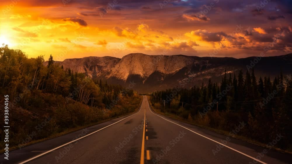 Cinemagraph Continuous Loop Animation. Scenic Road surrounded Rocky Mountains on a Cloudy Fall Season in Canadian Nature. Colorful Sunset Artistic Render. Taken near Whitehorse, Yukon, Canada. Cinemagraph Continuous Loop Animation. Scenic Road surrounded Rocky Mountains on a Cloudy Fall Season in Canadian Nature. Colorful Sunset Artistic Render. Taken near Whitehorse, Yukon, Canada.