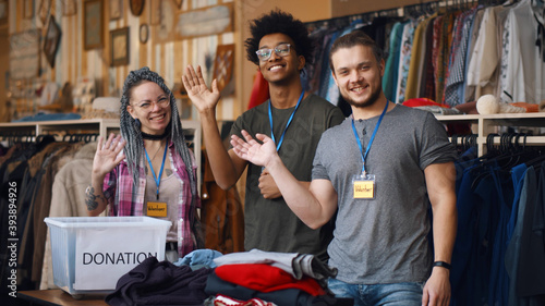 Portrait of young diverse volunteer group with clothes for donation photo