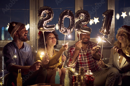 Cheerful couples making festive atmosphere at New Year eve. New Year, home party, friends time together