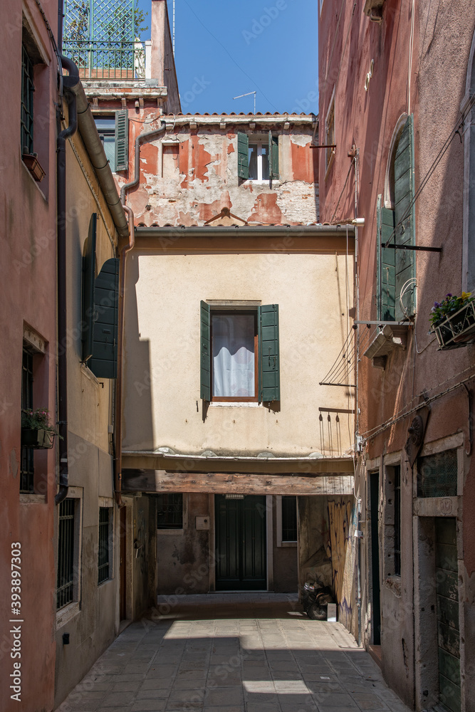 street view of narrow alley with unique architecture of residential building bridge underpass in venice italy