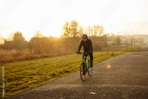 man on a blue bicycle in the morning cold season goes to work